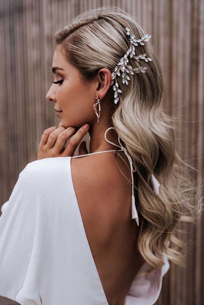 Lateral do cabelo presa com um pente decorado com folhas de cristal que rouba todas as atenções neste penteado perfeito para noiva, madrinha ou convidada de casamento.