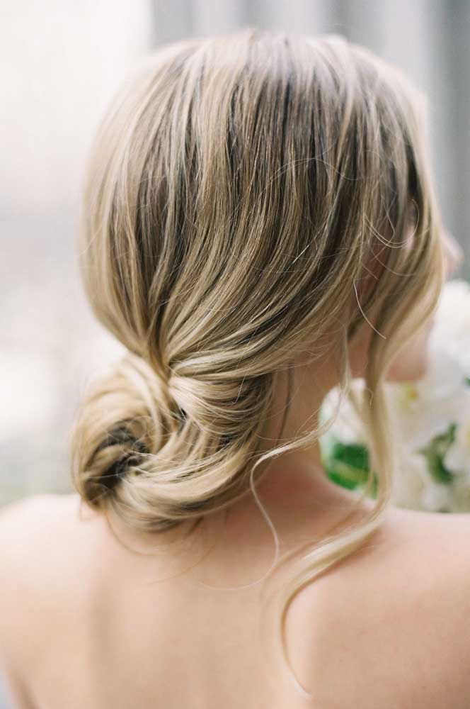 Penteado para casamento em coque baixo com uma mecha fininha da frente solta: simplicidade e muita elegância.