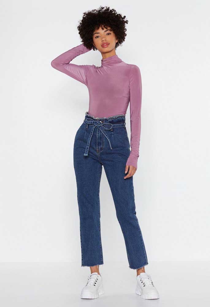 A blusa de gola alta e manga longa justa forma a combinação perfeita com jeans de cintura alta e tênis para um visual casual em dias de clima ameno.