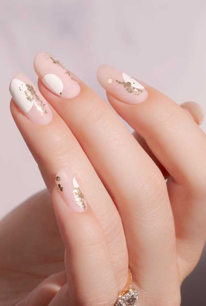 Usar tons nude não significa que suas unhas não terão destaque, e essa composição com branco e toques de dourado é a prova disso!