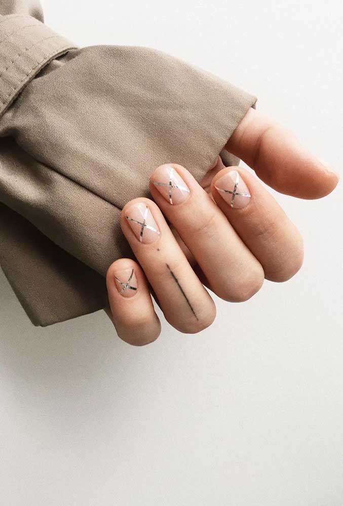 Essas unhas clarinhas saem do lugar comum com a aplicação de adesivos metalizados fininhos formando X em cada uma delas. 