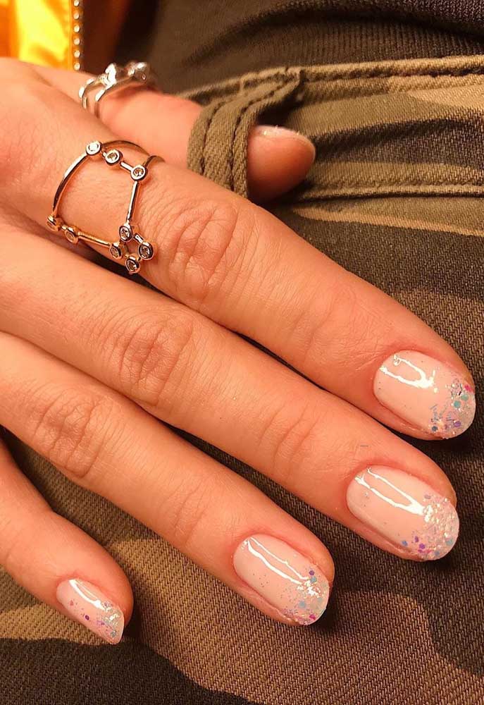 Uma composição com tons claros e muita diversão: a francesinha branca é substituída pelo esmalte transparente com glitter. 