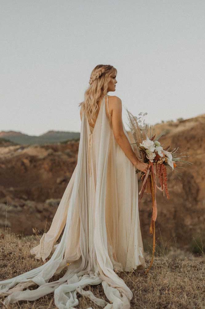 Leveza e movimento são as palavras certas para descrever esse vestido de noiva que mistura branco, bege e cinza claro num estilo boho.