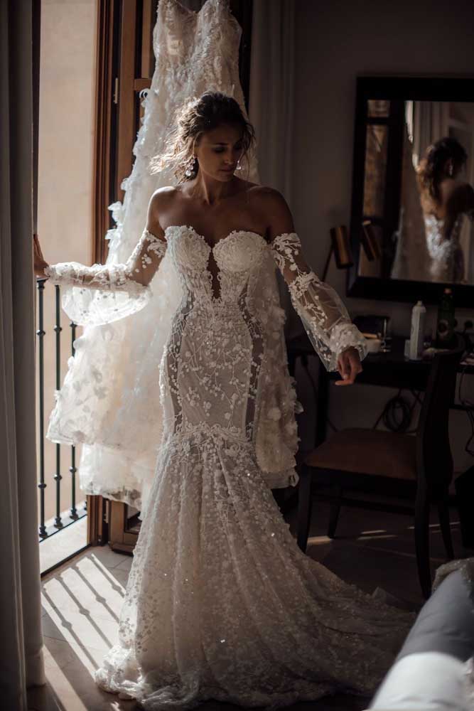 Por outro lado, esse vestido de noiva sereia sem alças combina transparência e bordados, com direito a uma manga longa bufante no estilo de uma luva longa.