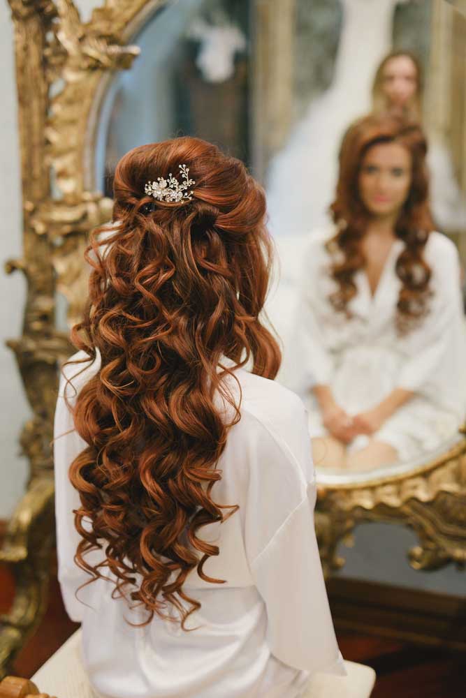 Cachos bem abertos e definidos caem como uma cascata a partir do topete adornado com uma presilha nesse penteado perfeito para casamentos e outros eventos formais. 