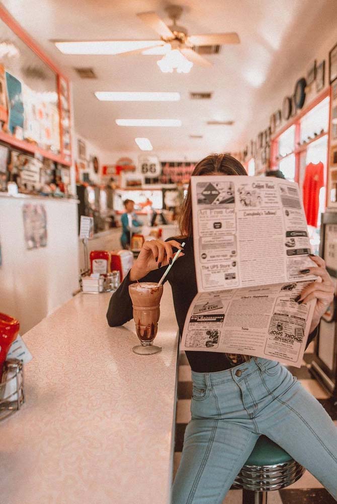 Um milkshake e um jornal para ler: uma foto tumblr retrô para ser transportada para outra época.