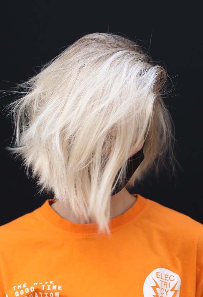 Loiro perolado na tintura completa desse cabelo curto com franja lateral alongada, com algumas mechas platinadas para trazer ainda mais luz para o visual.