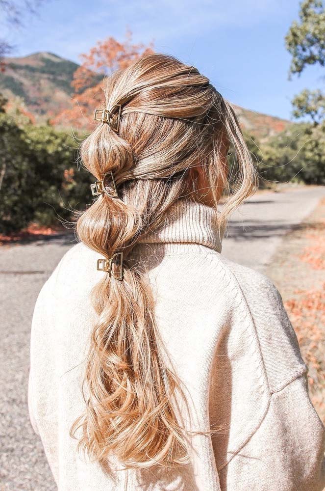 O penteado preso feito em camadas revela as gradações de tom e garante leveza e muito brilho para o cabelo longo castanho com luzes douradas e peroladas.