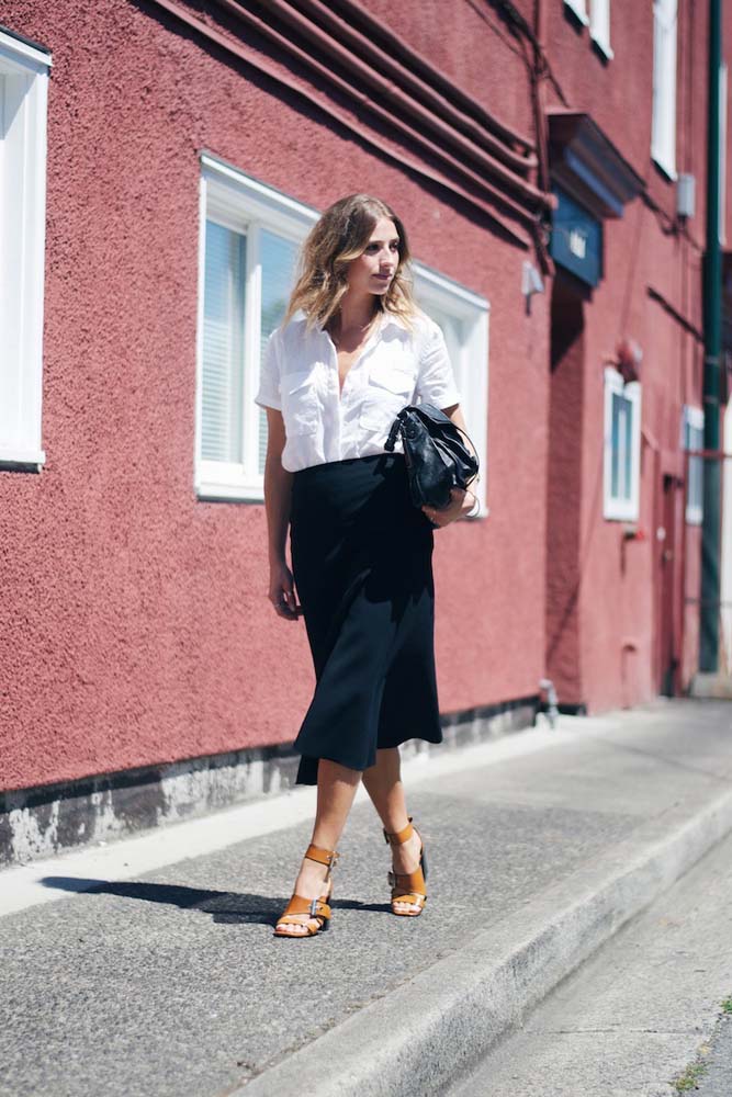Mais uma ideia super estilosa de look com saia preta para o trabalho, dessa vez combinando com camisa branca de manga curta e sandália de salto com tiras grossas caramelo. 