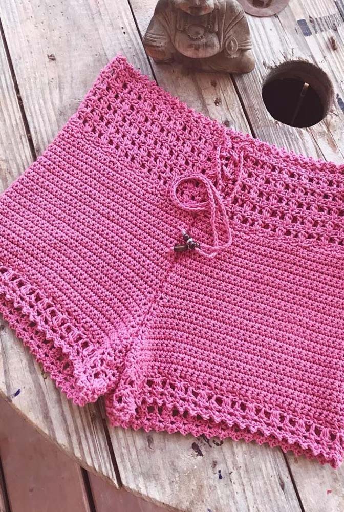 Modelo simples de shorts de crochê rosa chiclete com ponto alto na estrutura e vazados no cós e nas barras.