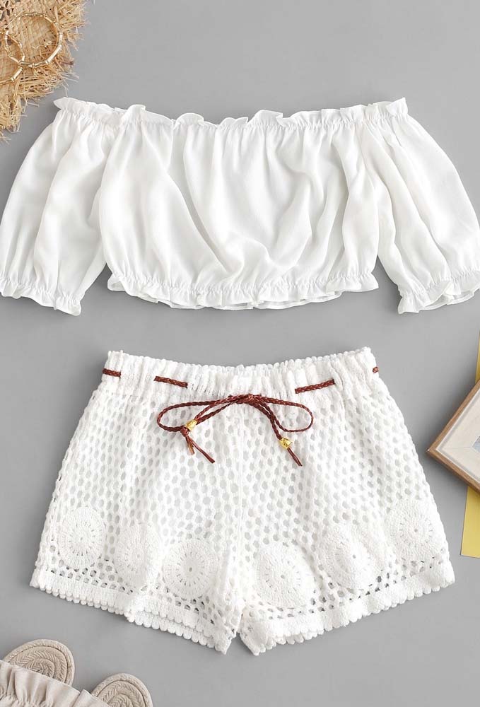 Quer uma ideia de look romântico para o verão? Aposte no cropped ombro a ombro de manga bufante e um shorts de crochê branco. 