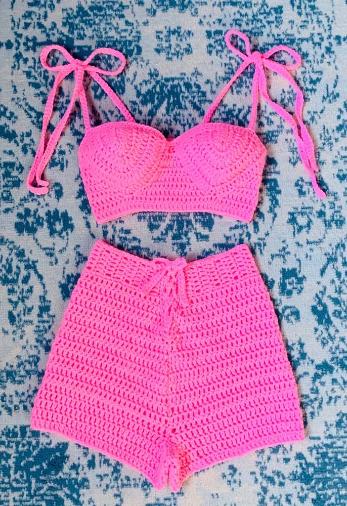 Para marcar presença, um conjunto de cropped de alcinhas e short de crochê de cintura alta rosa chiclete.