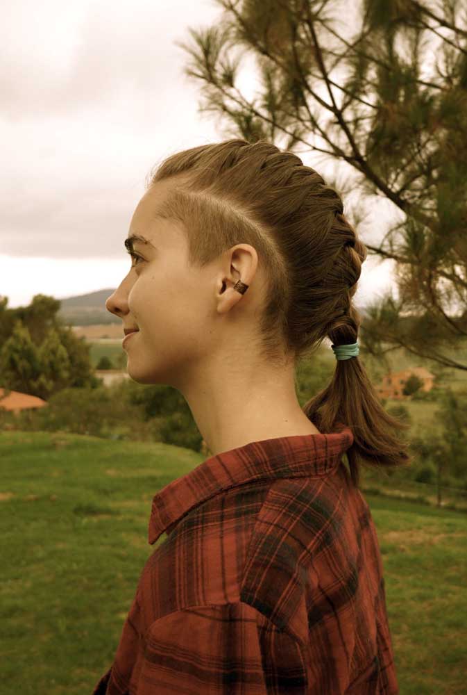 O penteado de trança embutida no topo da cabeça deixa em evidência o sidecut de altura média por toda a lateral do cabelo. 