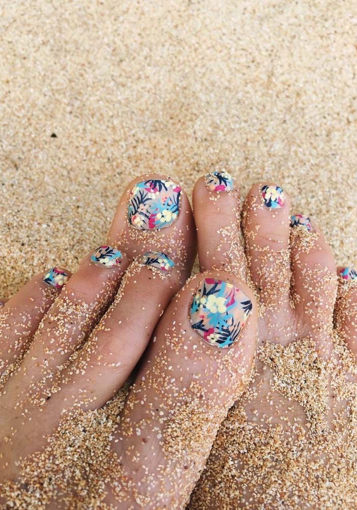 Lindas, divertidas e práticas, unhas do pé decoradas com adesivo florido.