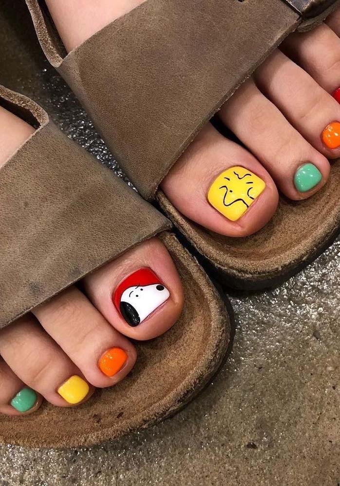 As apaixonadas pelo Snoopy e o Woodstock não vão conseguir resistir a essa composição super colorida de unhas do pé decoradas.