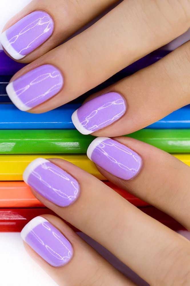 Mas se você quiser manter o branco nas pontinhas, pode inovar escolhendo outra cor para pintar o comprimento das unhas, como o lilás.