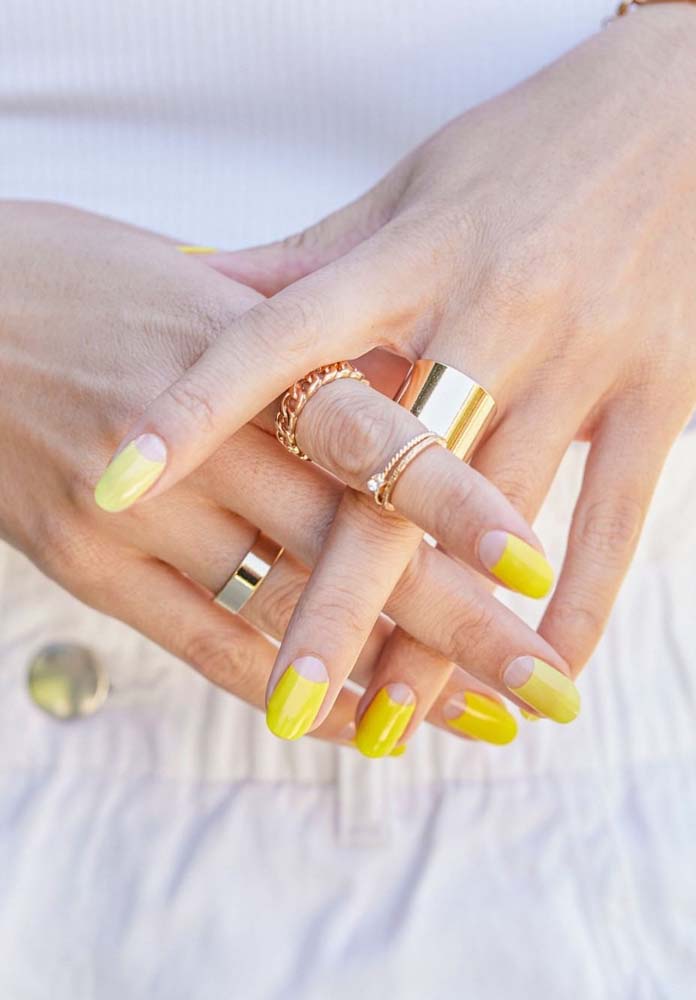 Confira essa ideia de unha tumblr amarelo vivo com meia lua no tom natural da unha.