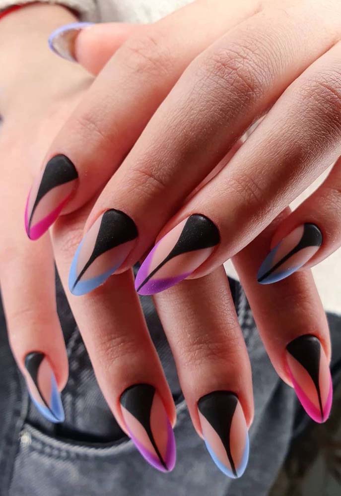 Nessa unha tumblr cheia de atitude e criatividade, o esmalte preto forma um triângulo da cutícula até a ponta da unha e encontra as francesinhas rosa, azul e roxa, enquanto o restante da unha permanece no seu tom natural. 