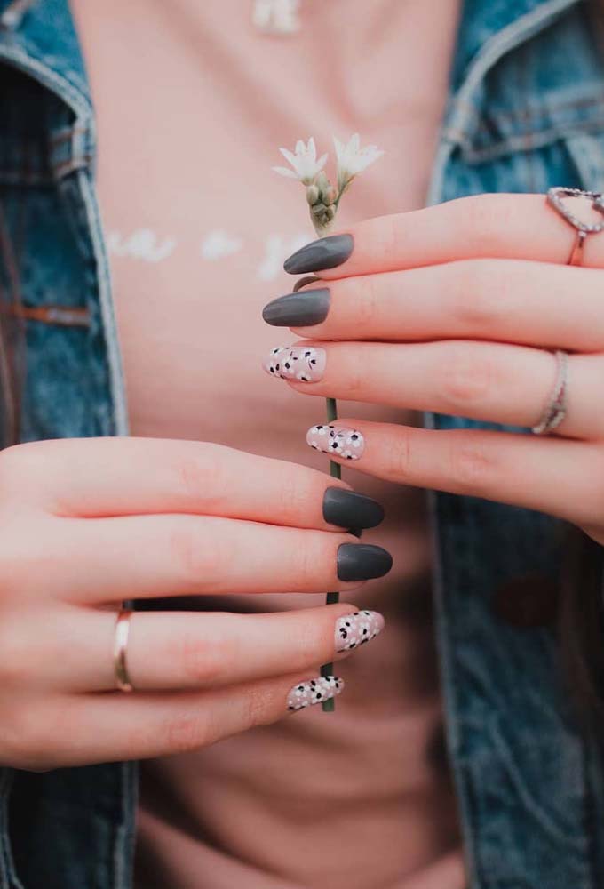 O cinza é sempre uma boa opção para chegar a um visual dark sem ter que usar o preto. Nessa composição, as unhas gêmeas rosinhas com desenhos de flores brancas contrastam com o cinza médio no restante das unhas. 