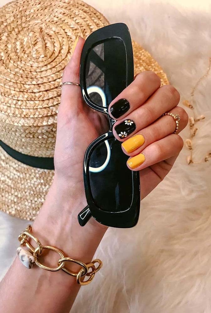 Você também pode apostar numa composição bem contrastante, como entre o preto e o amarelo vibrante para criar unhas tumblr bem charmosas como essas aqui com desenhos de margaridas feitas à mão.