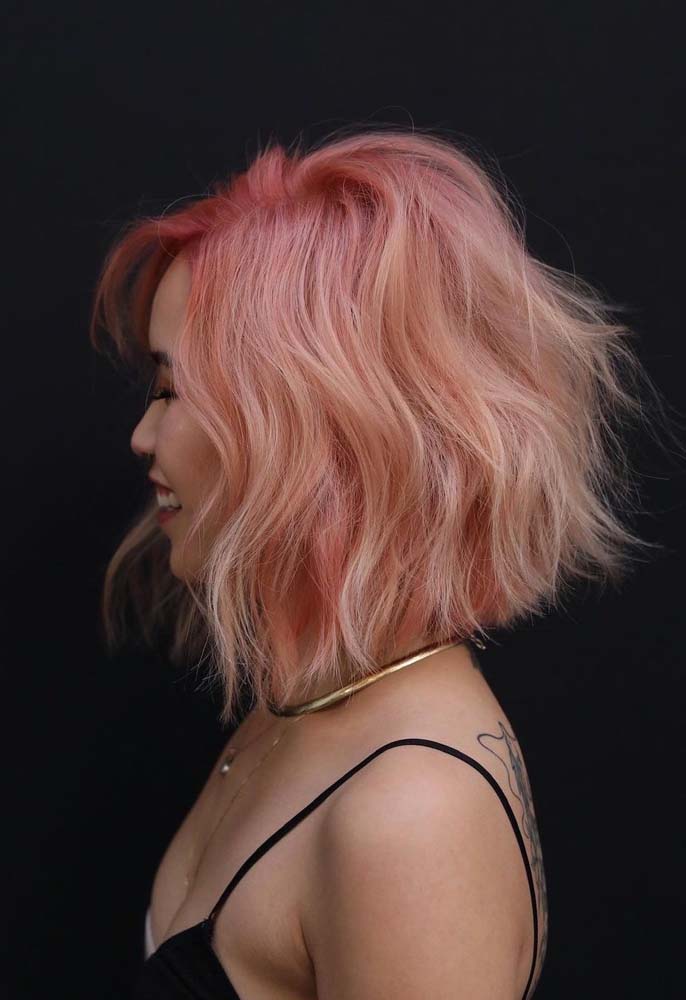 Jovial, estiloso e muito prático, cabelo curto desfiado com franja lateral rosa com mechas platinadas.