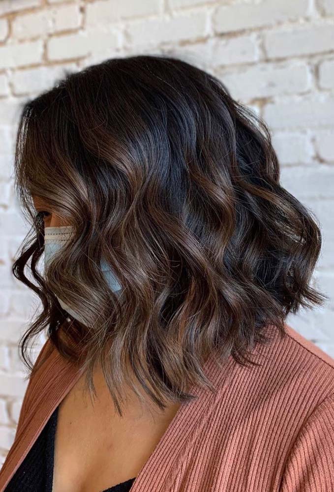 Mais profundidade para as ondas escuras desse cabelo curto com mechas castanhas. 