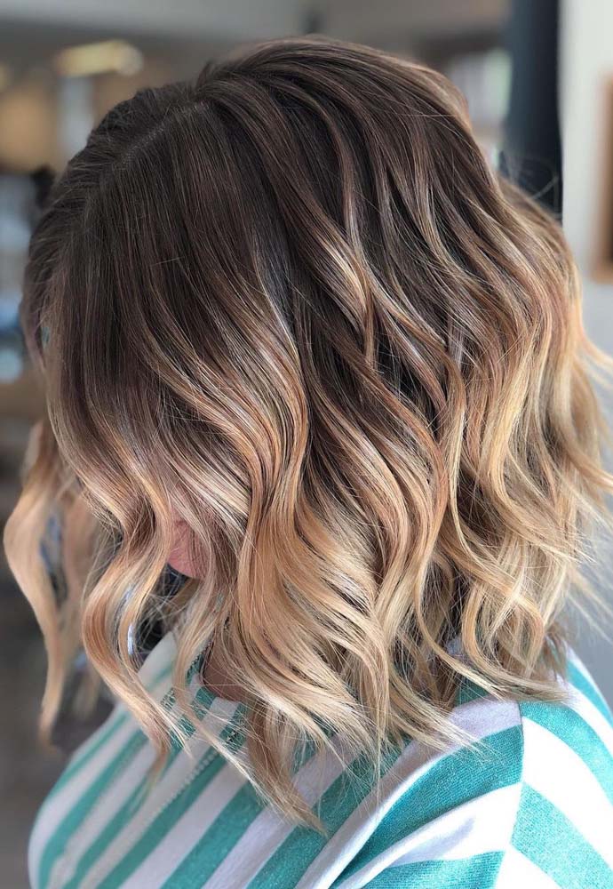 Um visual bicolor com degradê com castanho ao louro dourado no cabelo curto. 