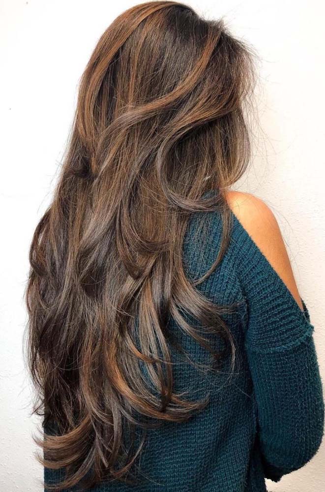 O corte degradê feminino faz com que as mechas longas caiam como cascatas pelas costas nesse exemplo.