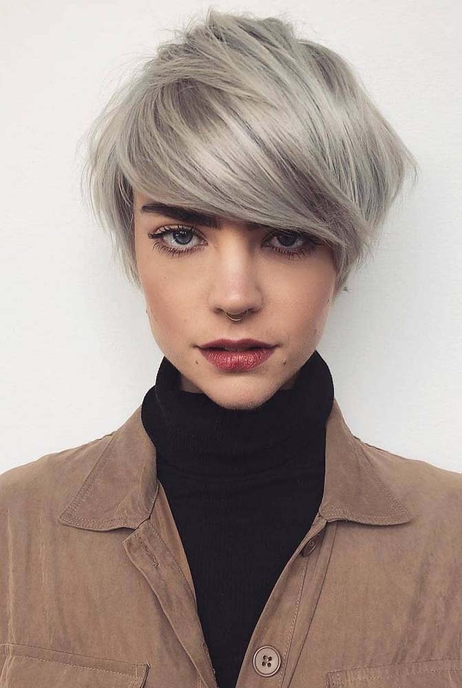 Uma franja lateral bem cheia para acompanhar esse corte pixie platinado com volume concentrado na parte de cima.