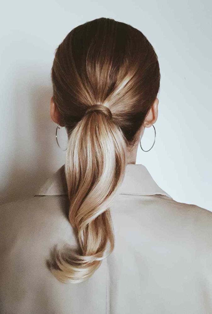 O rabo de cavalo baixo é penteado para cabelo médio fácil e super elegante, especialmente quando se usa uma mecha para esconder o elástico que mantém todos os fios juntos.