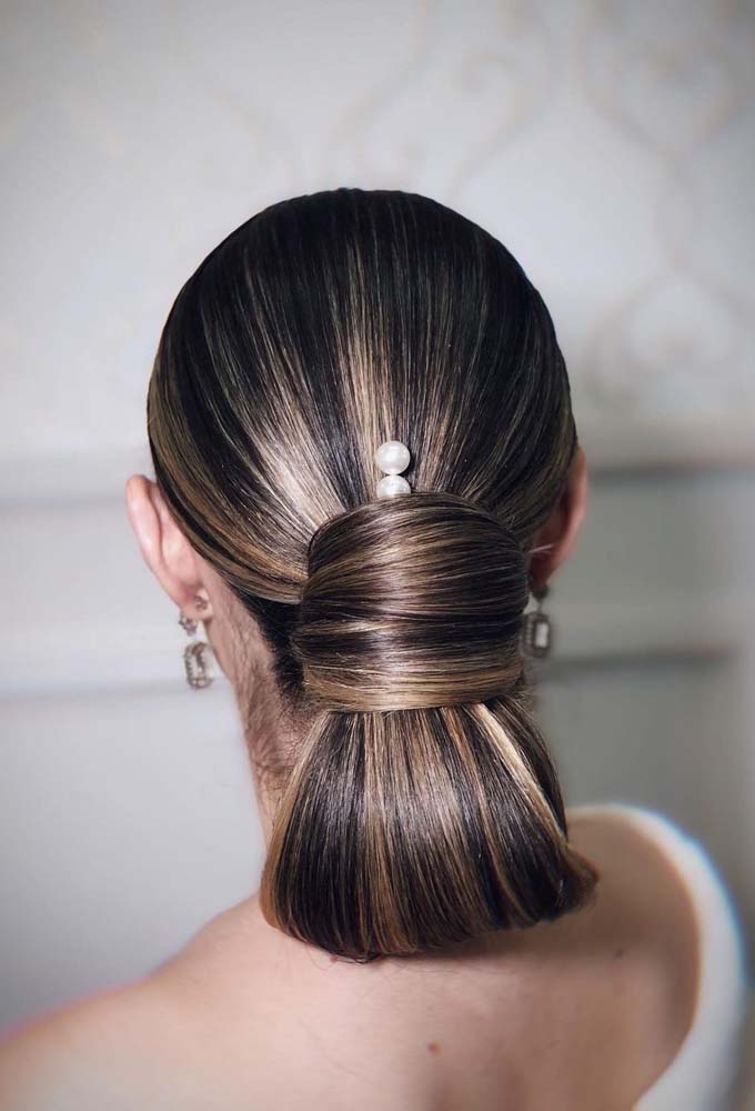 Elegância é a palavra certa para descrever esse penteado feito em cabelo médio preso, que dobra os fios na região da nuca e os envolve, quase como um laço.