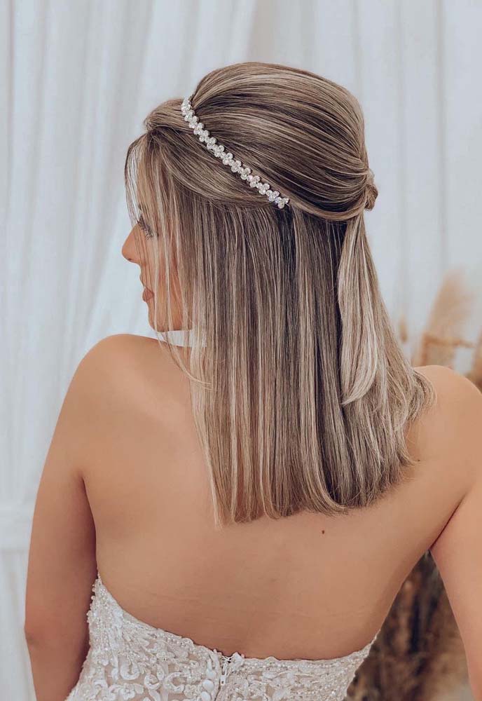 A tiara de cristal é outro acessório lindo e que ajuda a dividir a parte da frente do topo volumoso nesse penteado de cabelo médio para formatura.