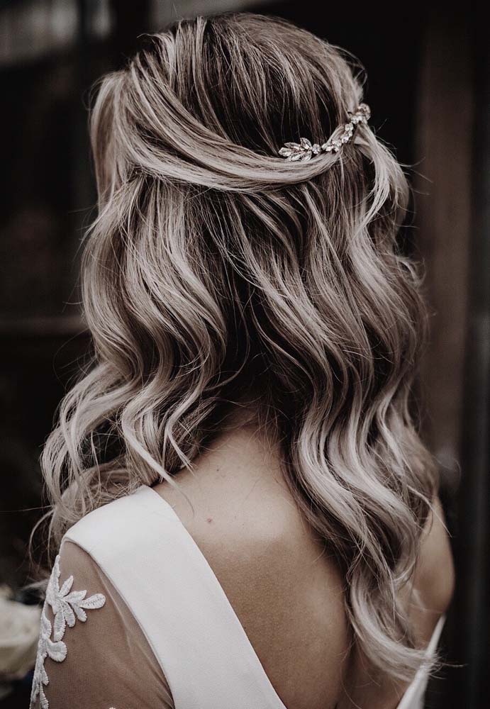 Perfeito para casamentos, um penteado para cabelo médio só com duas mechas finas da frente presas na parte de trás e os restante dos fios soltos, caindo numa cascata pelos ombros.