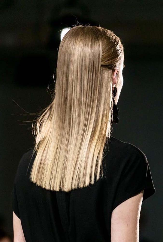 Penteado cabelo médio liso e sem volume algum: o truque é dividir o cabelo na altura da orelha e depois selecionar as mechas da frente, prendendo-as entre as duas grandes mechas na parte de trás. 