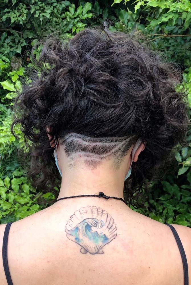 Nesse corte bob curto no cabelo ondulado, o undercut é feito só na nuca e ganha um riscado delicado de linhas orgânicas que se encontram, como num rio.