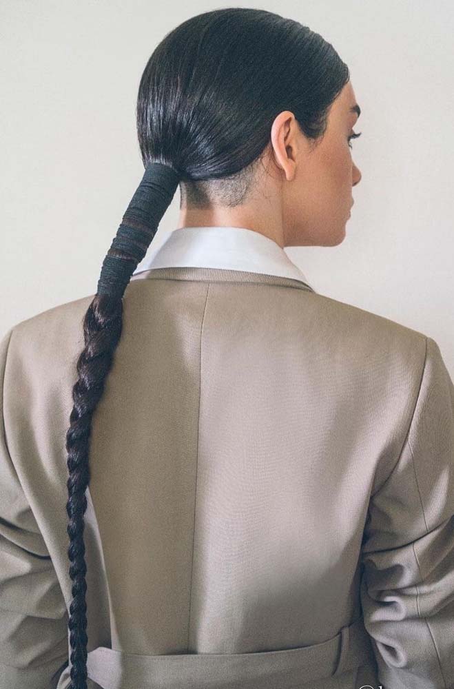 Bem discreto, mas não sem personalidade, um undercut feminino com cabelo longo organizado em uma trança tradicional única.