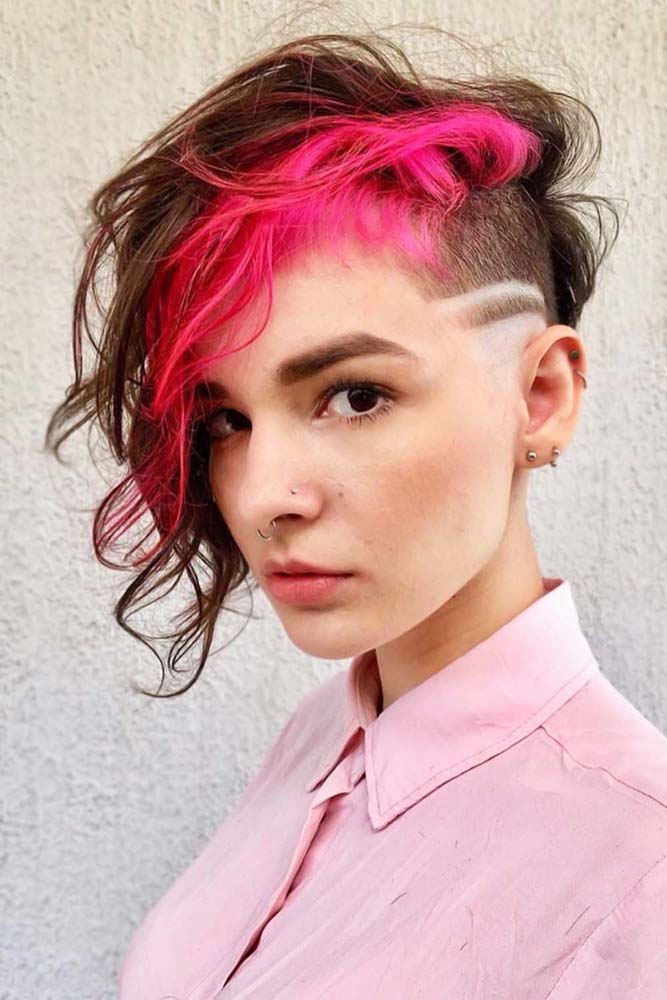 Aposte na criatividade para fazer um visual que expresse o seu estilo pessoal, como nesse undercut feminino com riscas e uma mecha rosa chiclete na franja lateral ondulada.