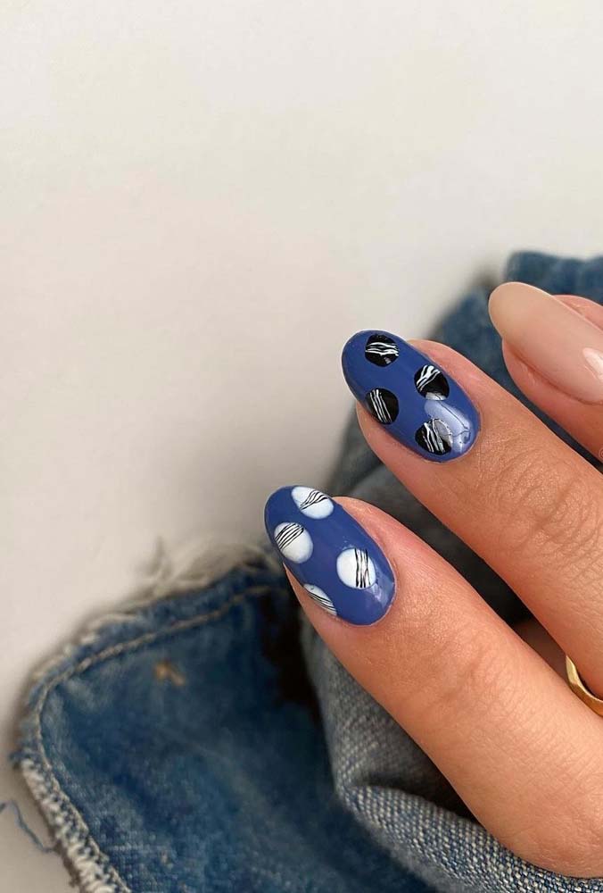 Inspire-se também nessa ideia de unhas gêmeas azuis escuras com bolinhas pretas e brancas riscadinhas.