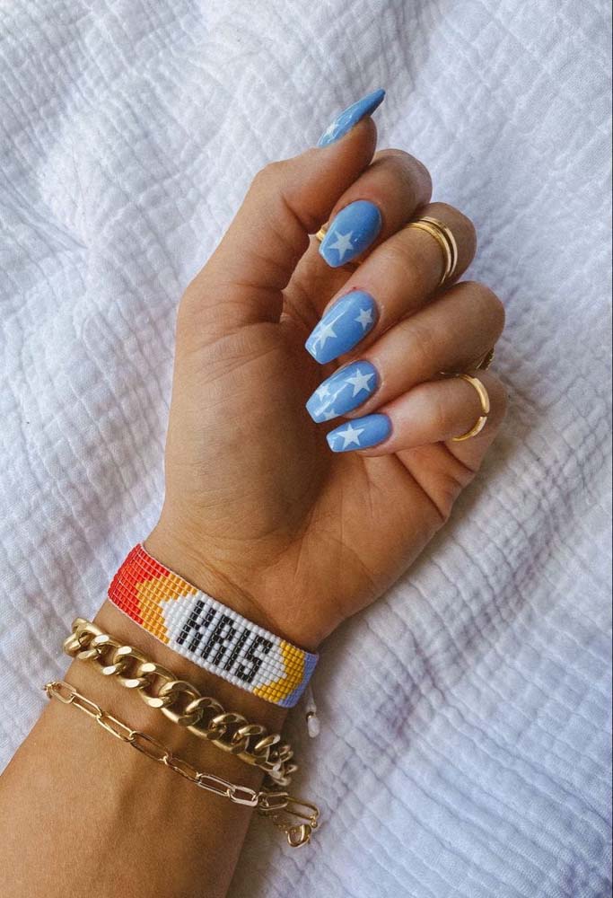 As estrelas são o tema dessas unhas decoradas azul claro com branco bem jovens e delicadas.