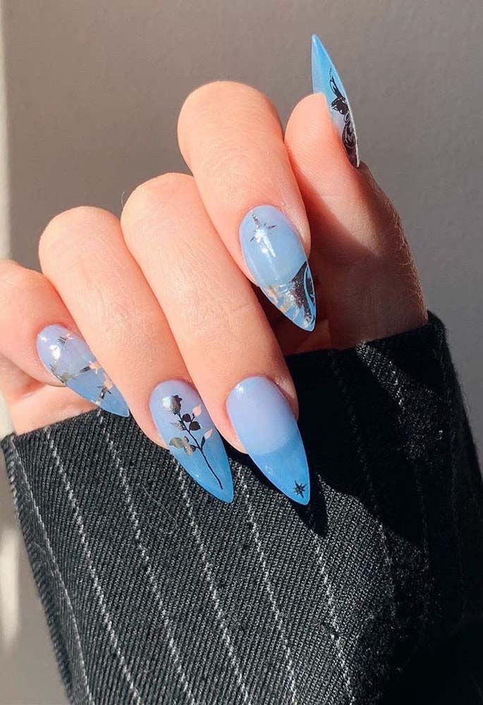 Dê uma olhada na atitude dessas unhas stiletto azul celeste com adesivos com acabamento metalizado.