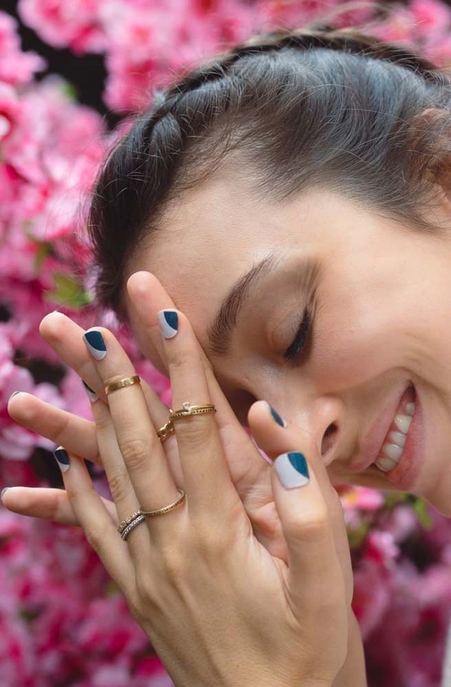 Unhas decoradas com dois tons de azul numa composição com divisão diagonal. 