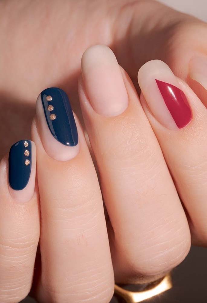 Outra ideia de unhas gráficas, dessa vez numa composição mais sóbria e elegante, valorizando o tom natural da unha e criando áreas de cor azul marinho e bordô. 