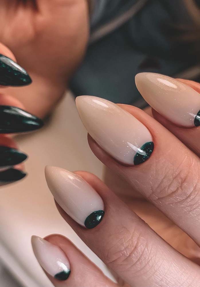 Unhas perfeitas decoradas. Em uma mão, é o esmalte branco que se destaca, já na outra é o esmalte preto