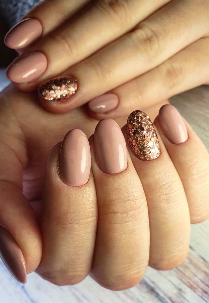 Unhas simples com glitter: o tom nude é um dos preferidos para um efeito elegante e moderno