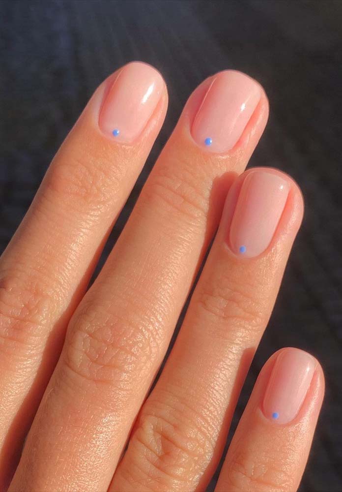 O charme dos pontinhos azuis na base das unhas simples e cheias de estilo