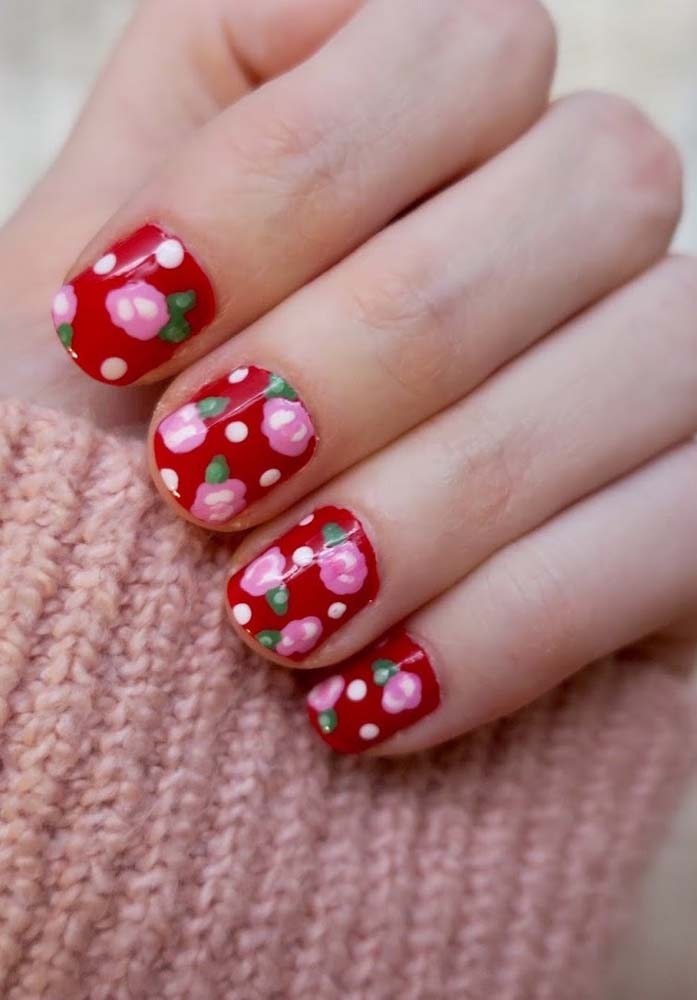 Um toque de romantismo nas unhas vermelhas decoradas com flores