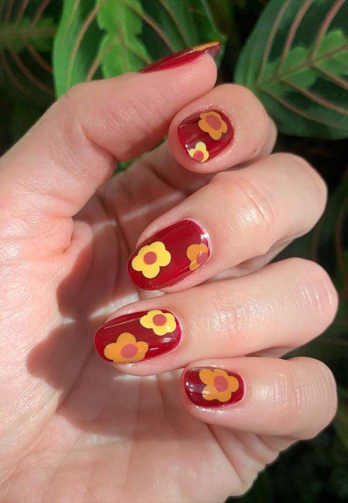 Já aqui, a dica é fazer flores amarelas para animar a esmaltação vermelha