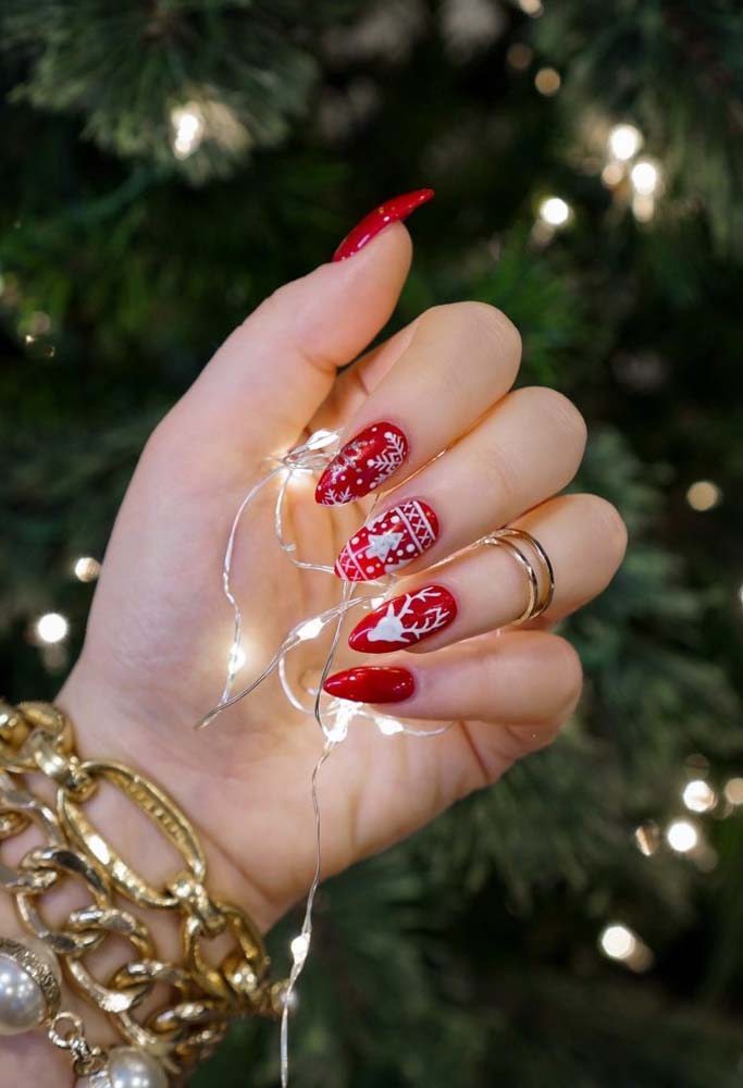 Já aqui, as unhas vermelhas com branco trazem desenhos de natal